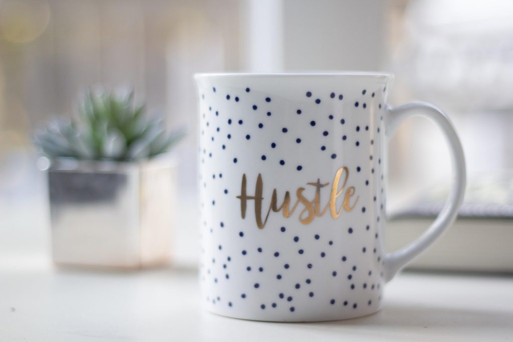 A mug with the word 'hustle' written on it